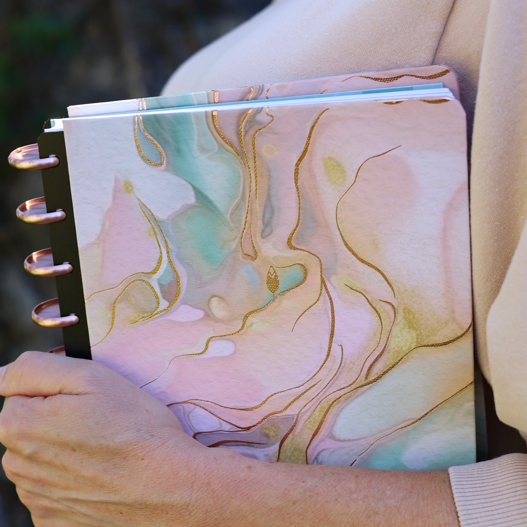 An alcohol ink design in shades of terracotta and pink is the featured hard cover on this inkwell press planner system with rose gold discs