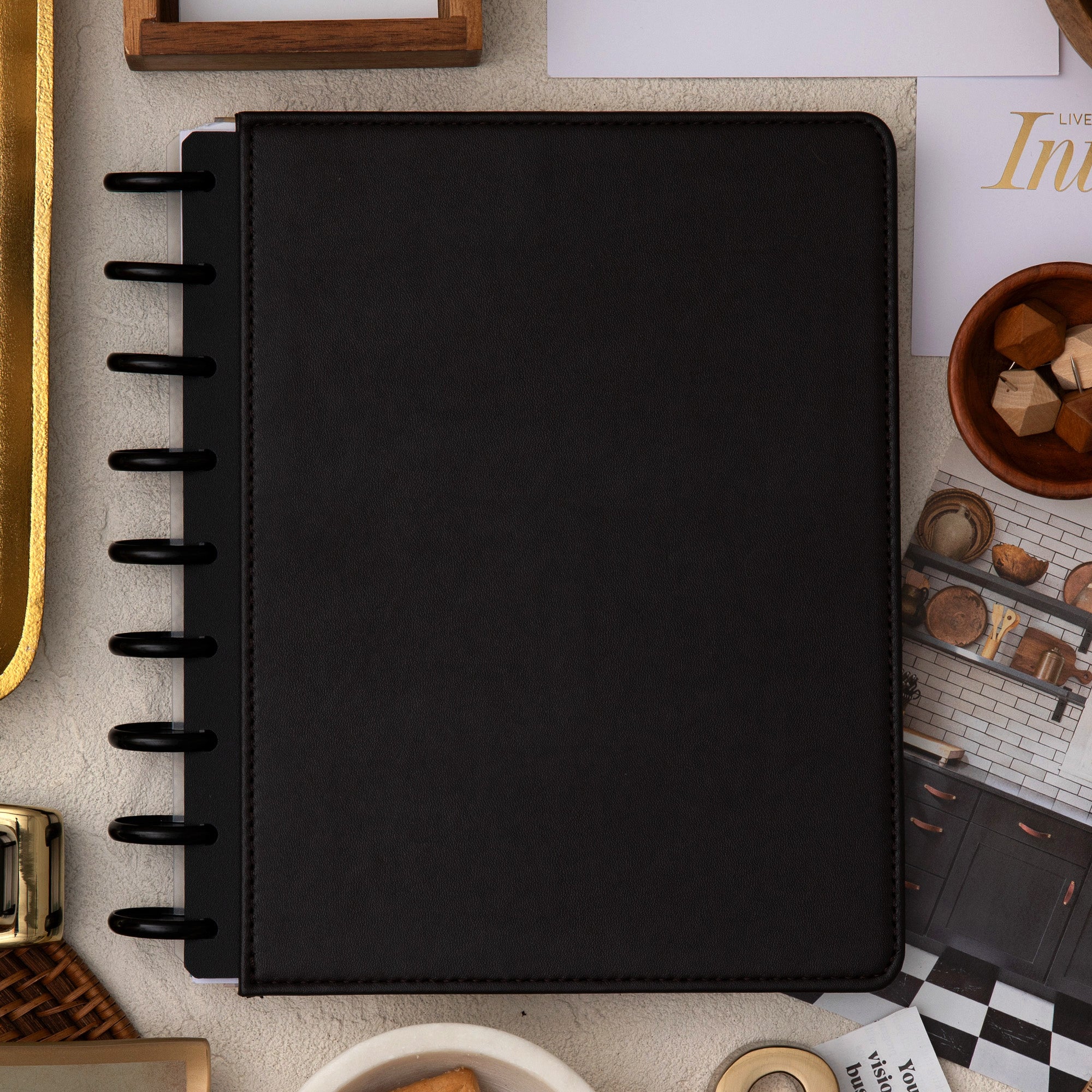 brown faux leather cover with black disc on this inkwell planner surrounded by office supplies