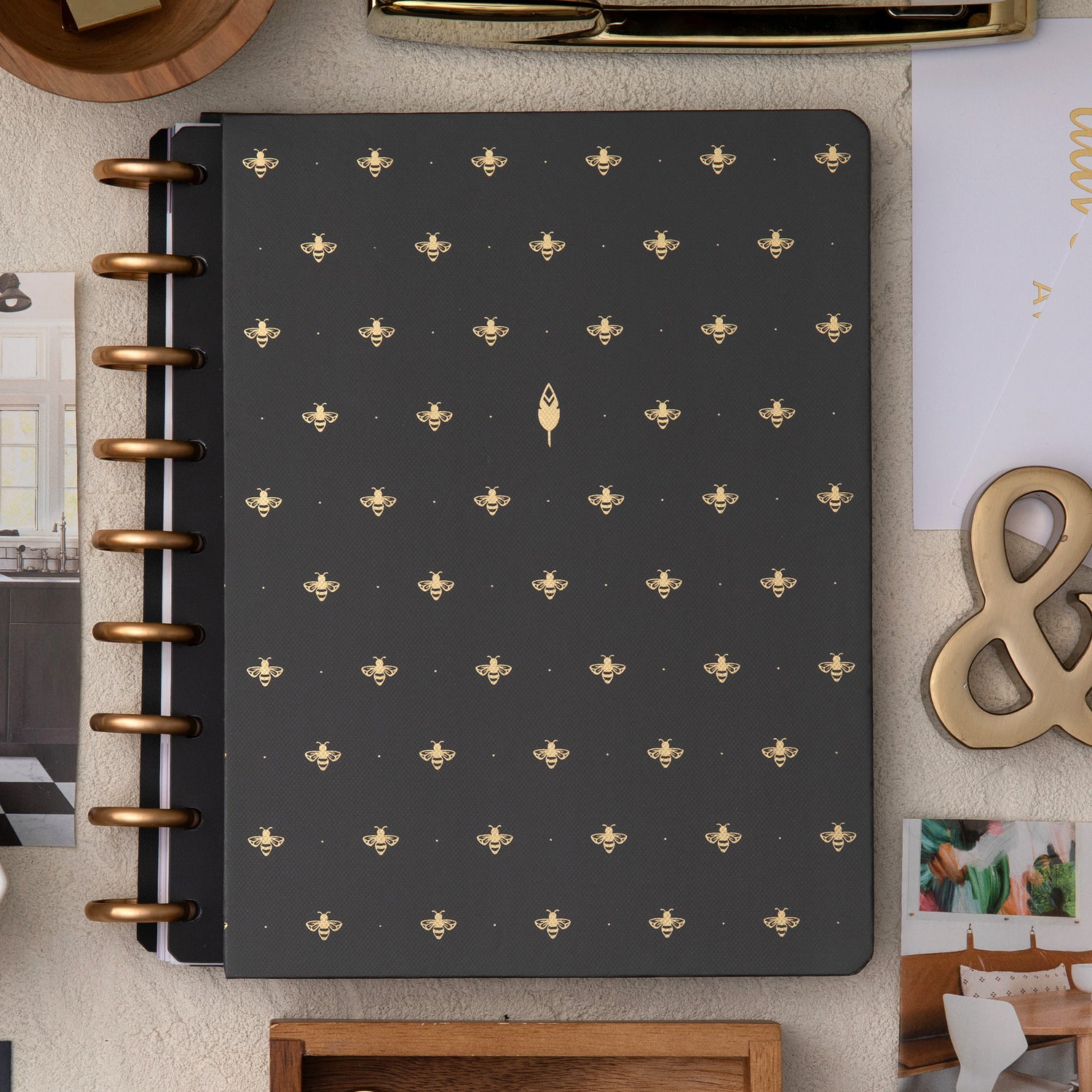 golden bees pattern on this hard cover with gold disc on this inkwell planner surrounded by office supplies