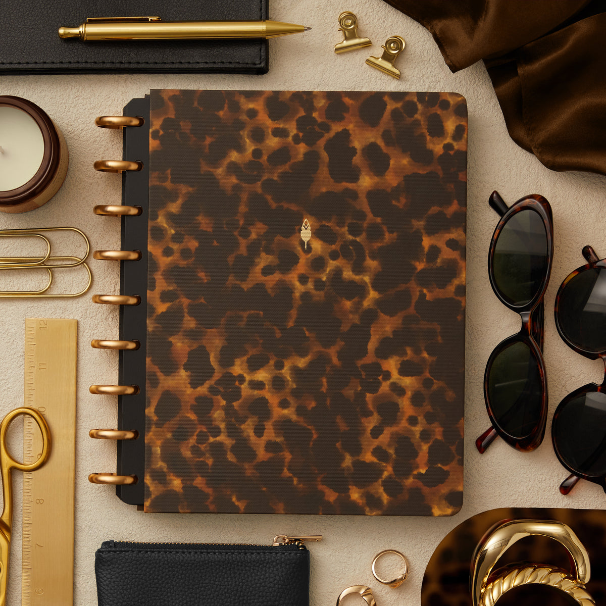 gold disc binding and leopard print front cover alongside office supplies