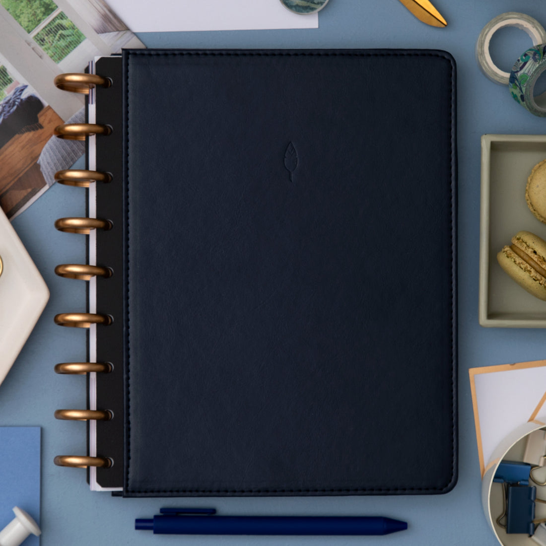 sapphire faux leather cover with gold disc on this inkwell planner surrounded by office supplies