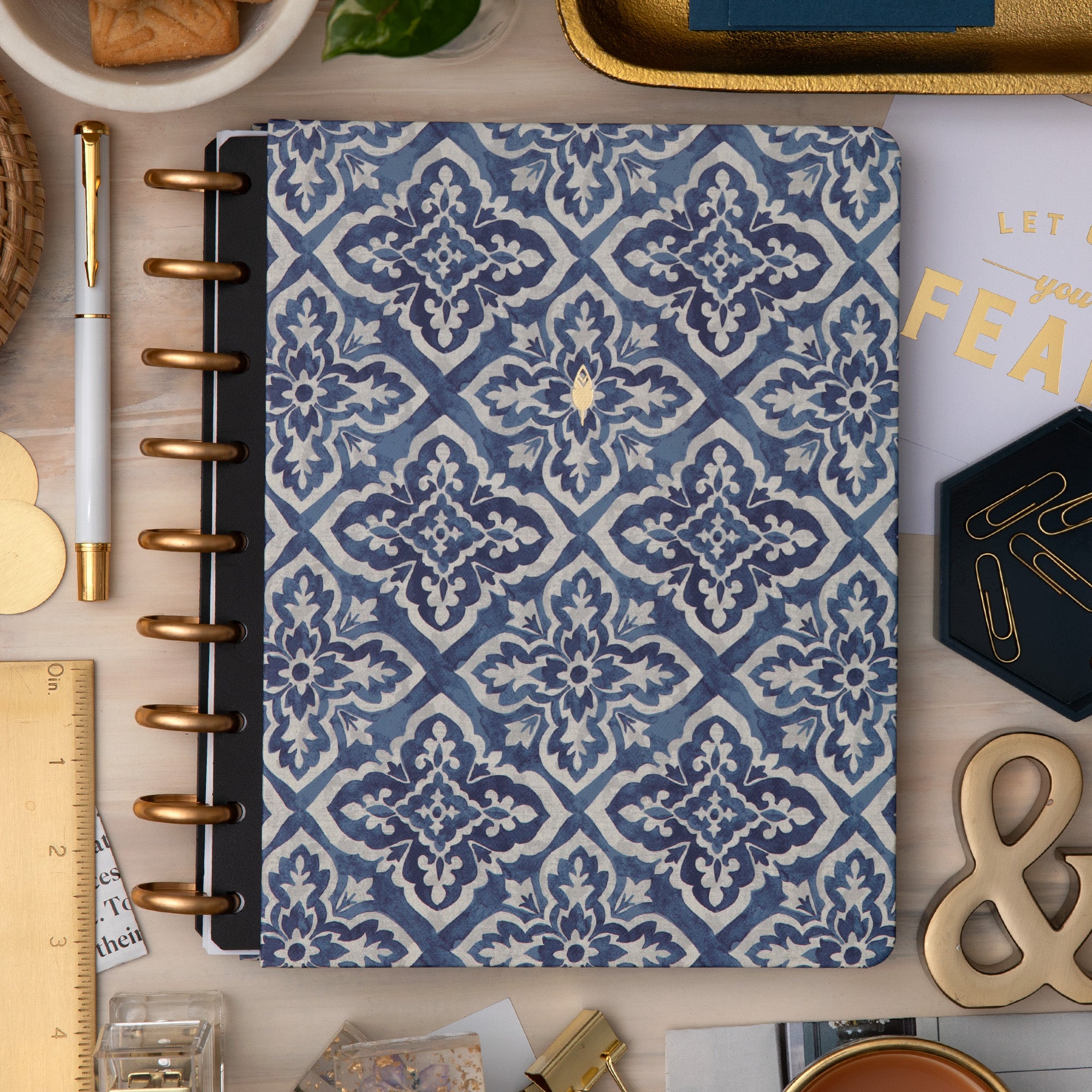 front cover with blue geometric pattern on a desk with office supplies