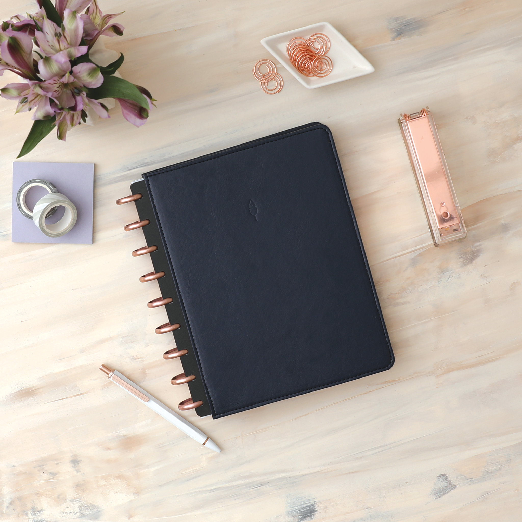 Vegan leather deep navy blue cover with embossed quill logo, gold discs, and in a 7x9 planner size